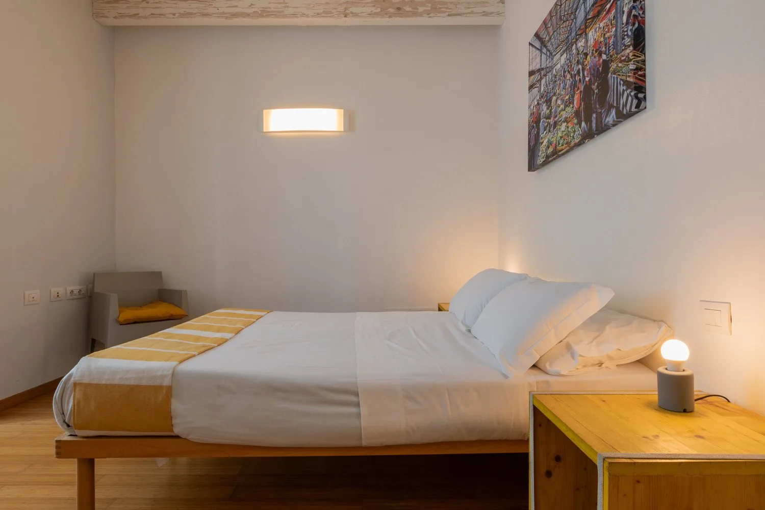 Un dormitorio con una cama bien hecha y una mesita de noche.