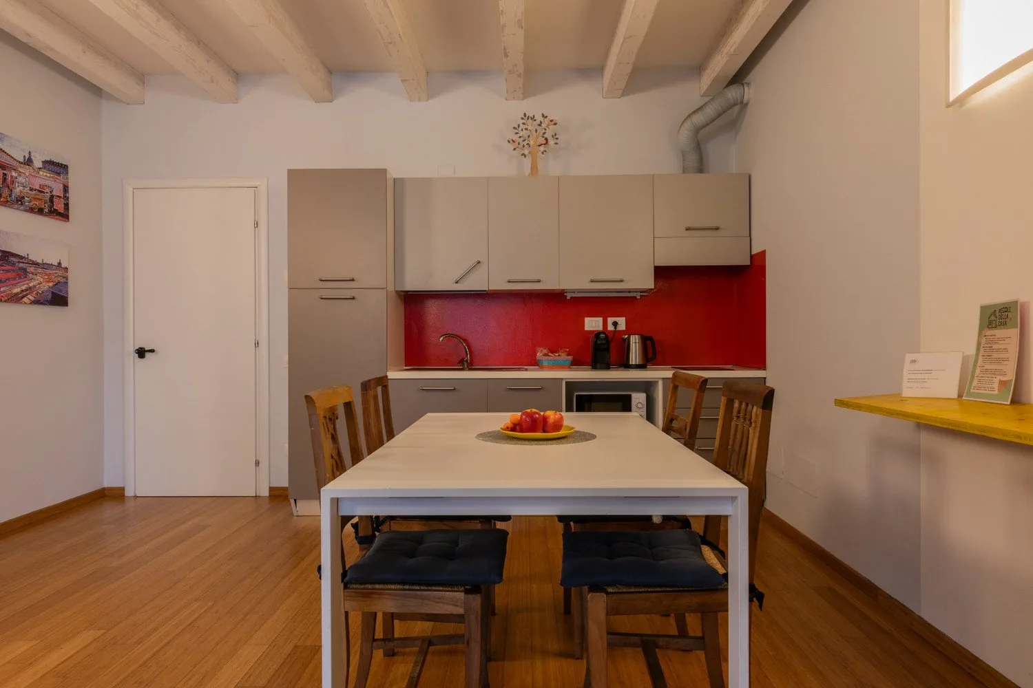 Un comedor con mesa y sillas está frente a una cocina compacta.