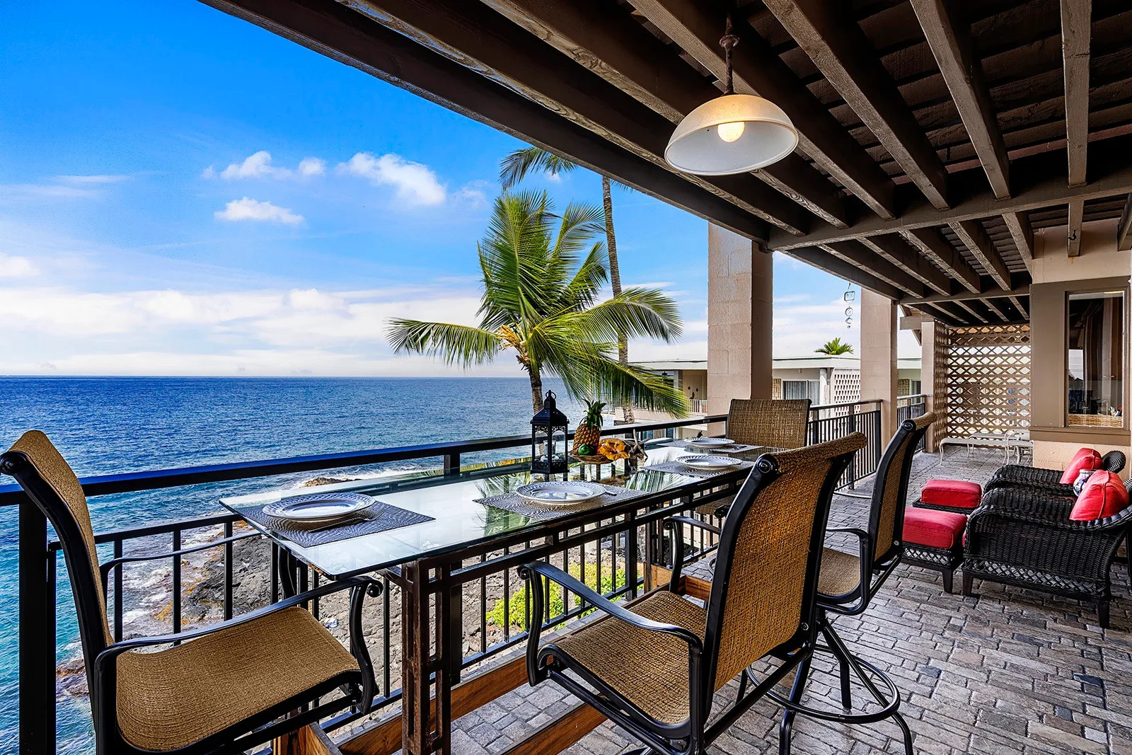 Comedor cubierto junto al mar, con una mesa larga frente al océano.