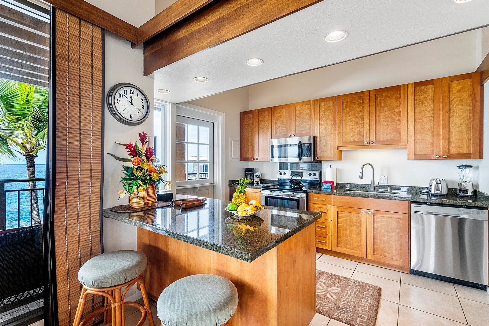 Una cocina con gabinetes de madera, una isla central y una puerta corrediza de vidrio.