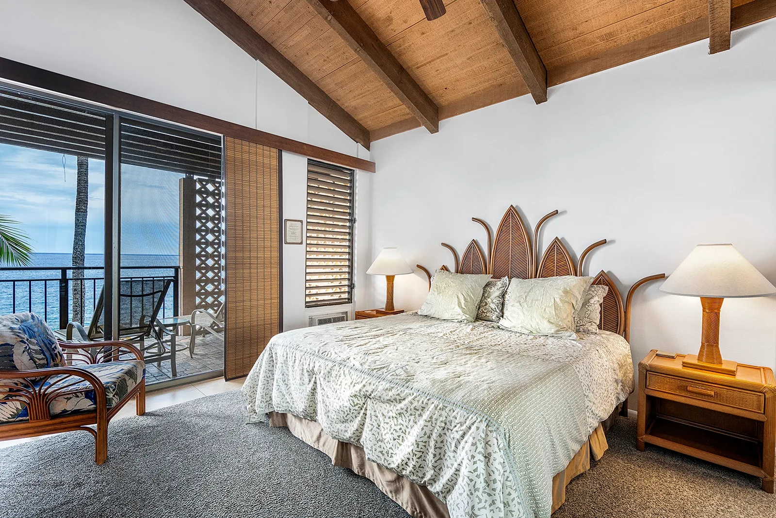Un dormitorio con una cama grande y puertas corredizas de vidrio que dan a un balcón.