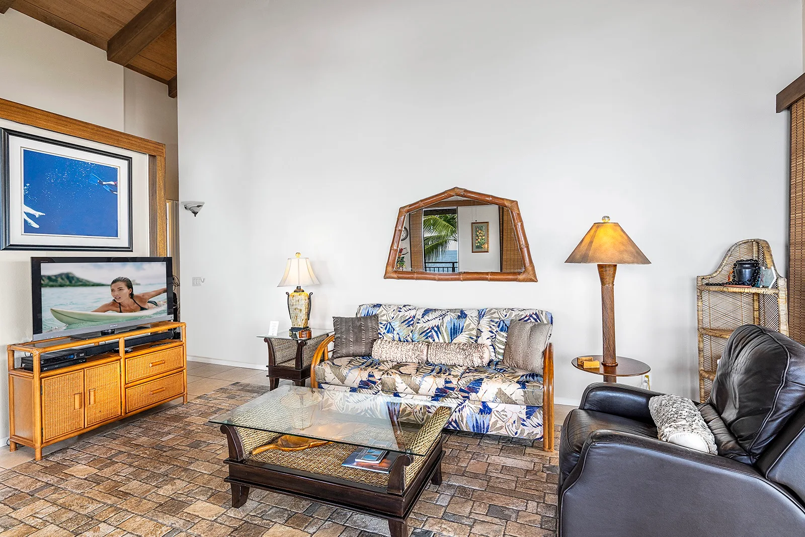 Una sala de estar con un sofá estampado, un sillón y una mesa de centro.