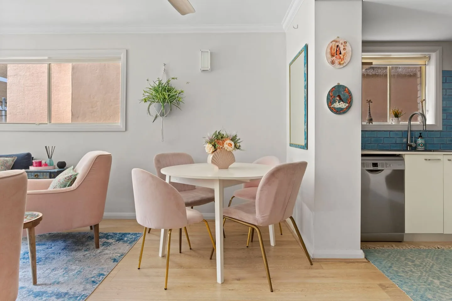 A dining area with a round table and pink seating.