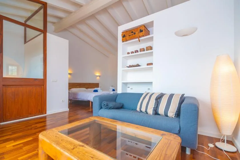 A bright living room with blue seating and a glass-topped coffee table.