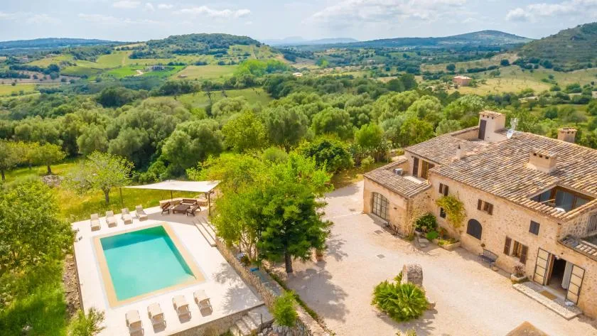 A countryside property with a swimming pool and surrounding green hills.