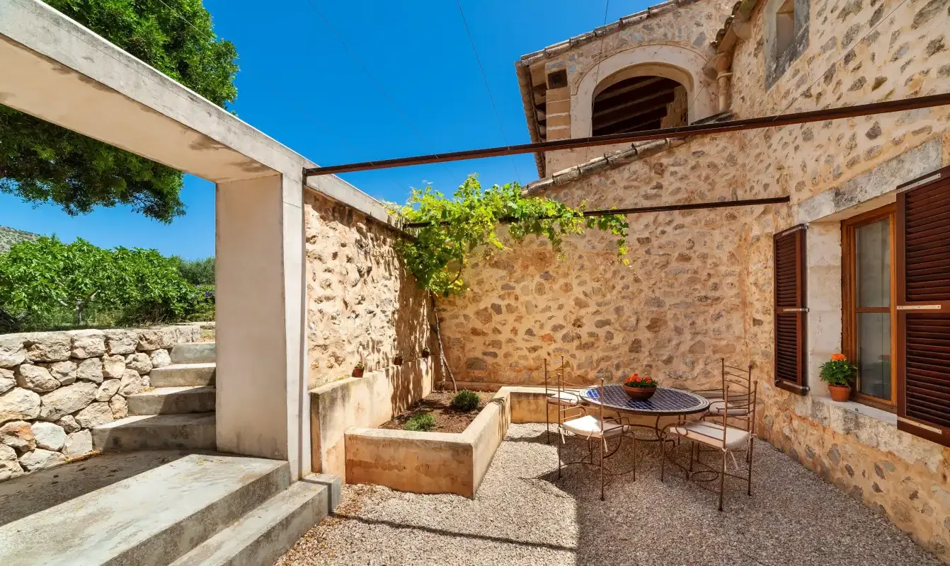 A stone courtyard with outdoor seating and a raised planter.