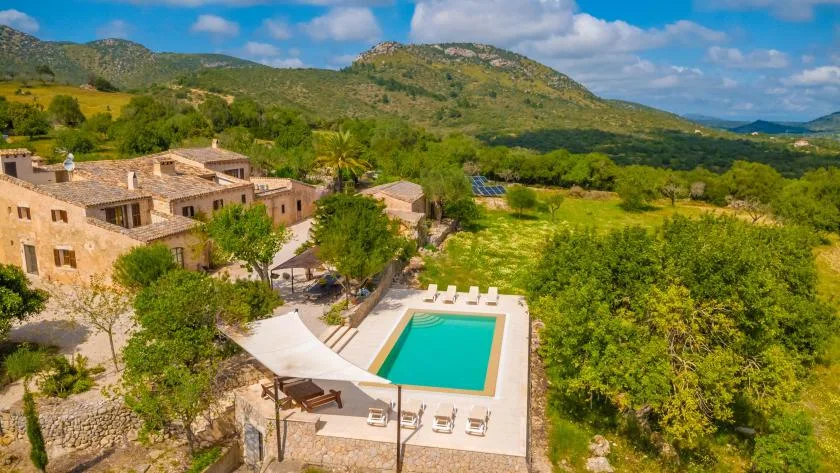A countryside property with a swimming pool and surrounding green hills.