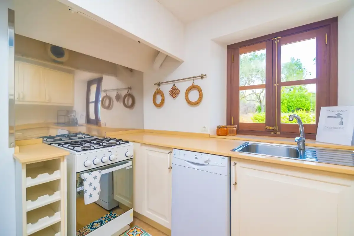 A bright kitchen with a gas cooktop, sink, and window.