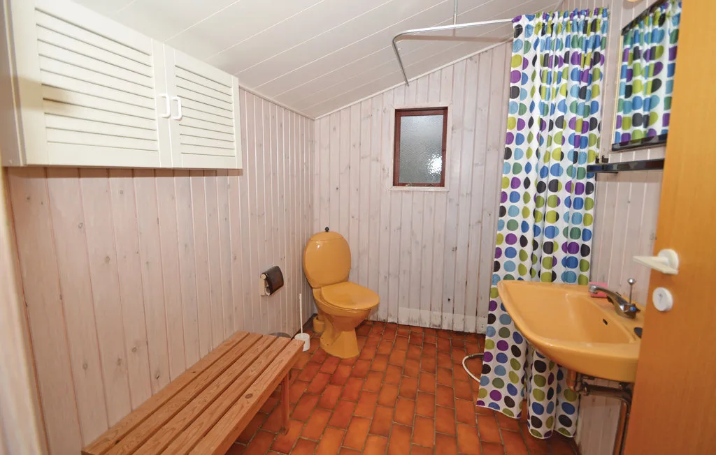 A bathroom with a sink, toilet, and colorful shower curtain.