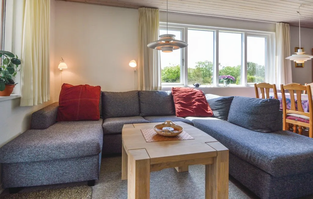 A living room with a large sectional sofa and a wooden coffee table.