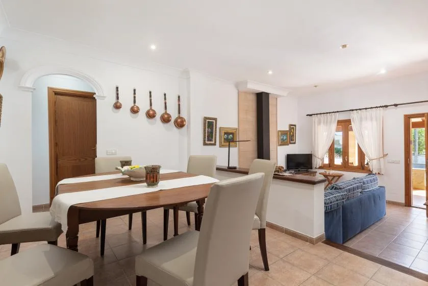 An open-plan dining and living area with a table and seating beside the windows.
