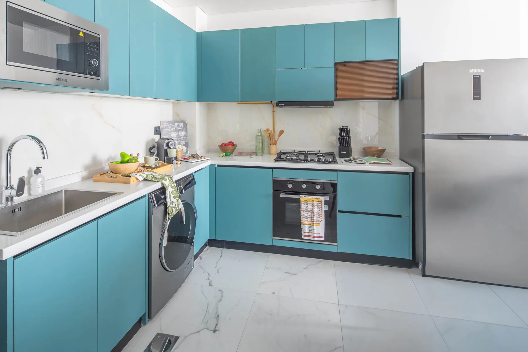 A modern kitchen with turquoise cabinets, a countertop, and stainless steel appliances.