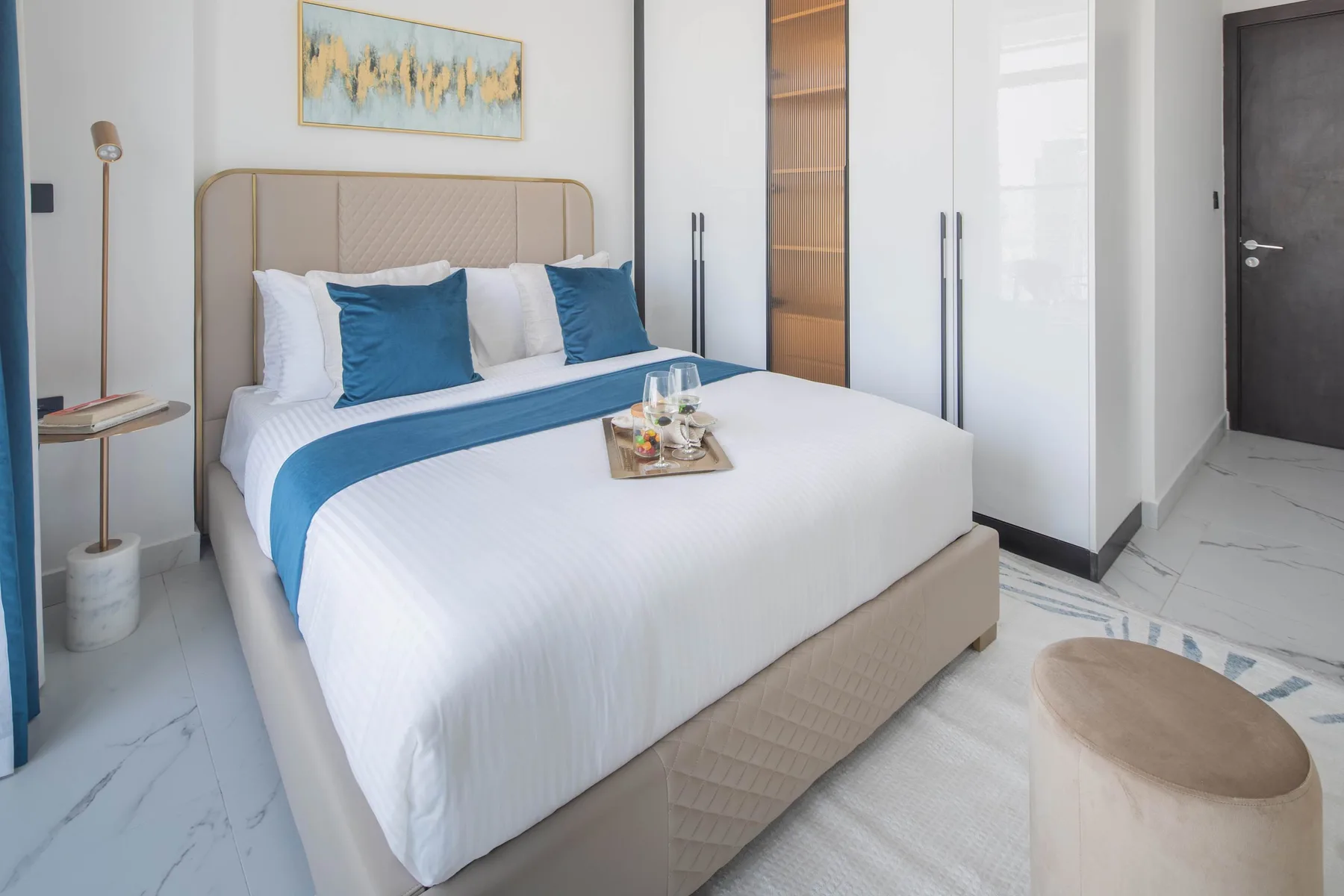 A bright bedroom with a neatly made bed and built-in wardrobes.