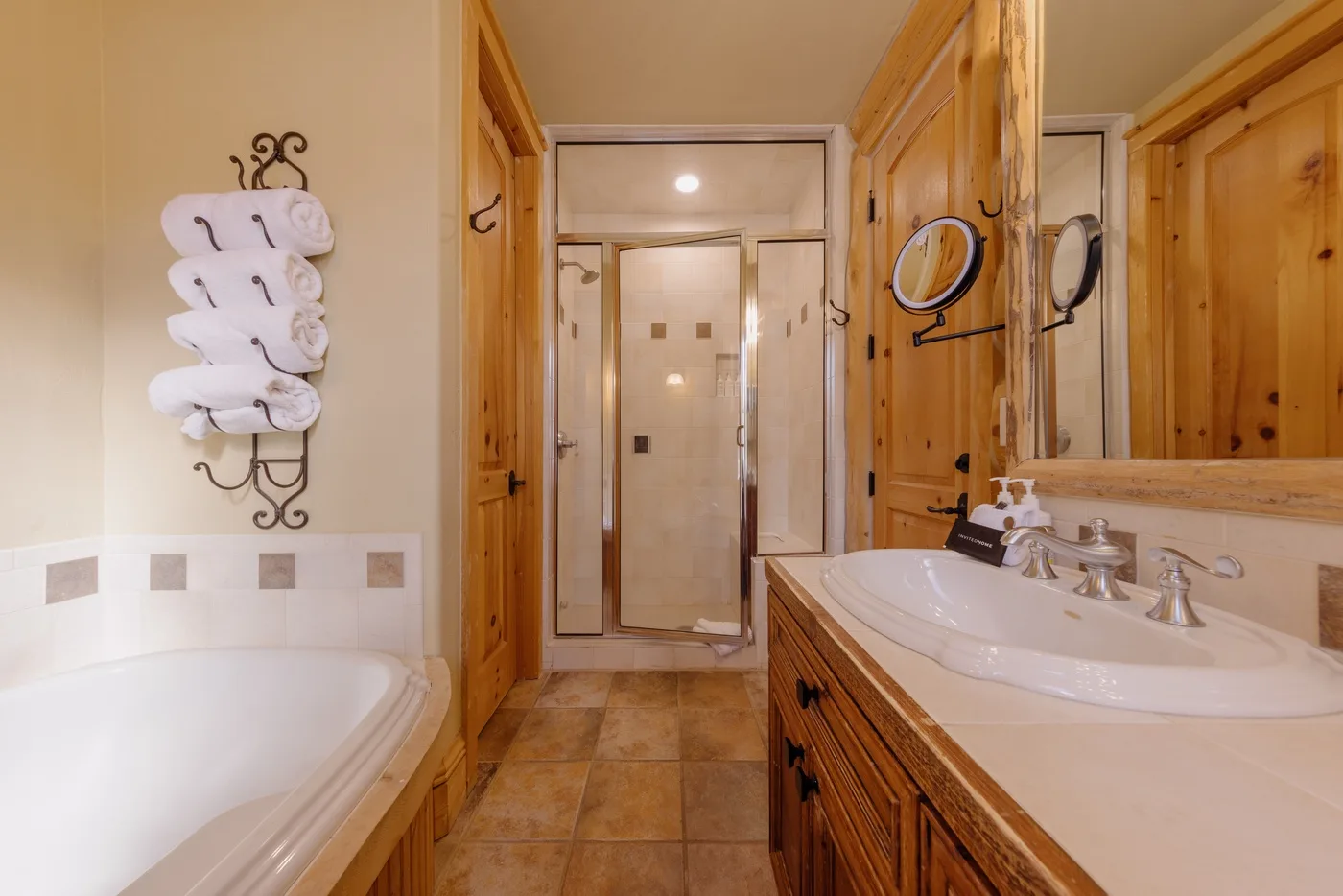 Un baño con bañera, lavabo con mueble y ducha de vidrio.