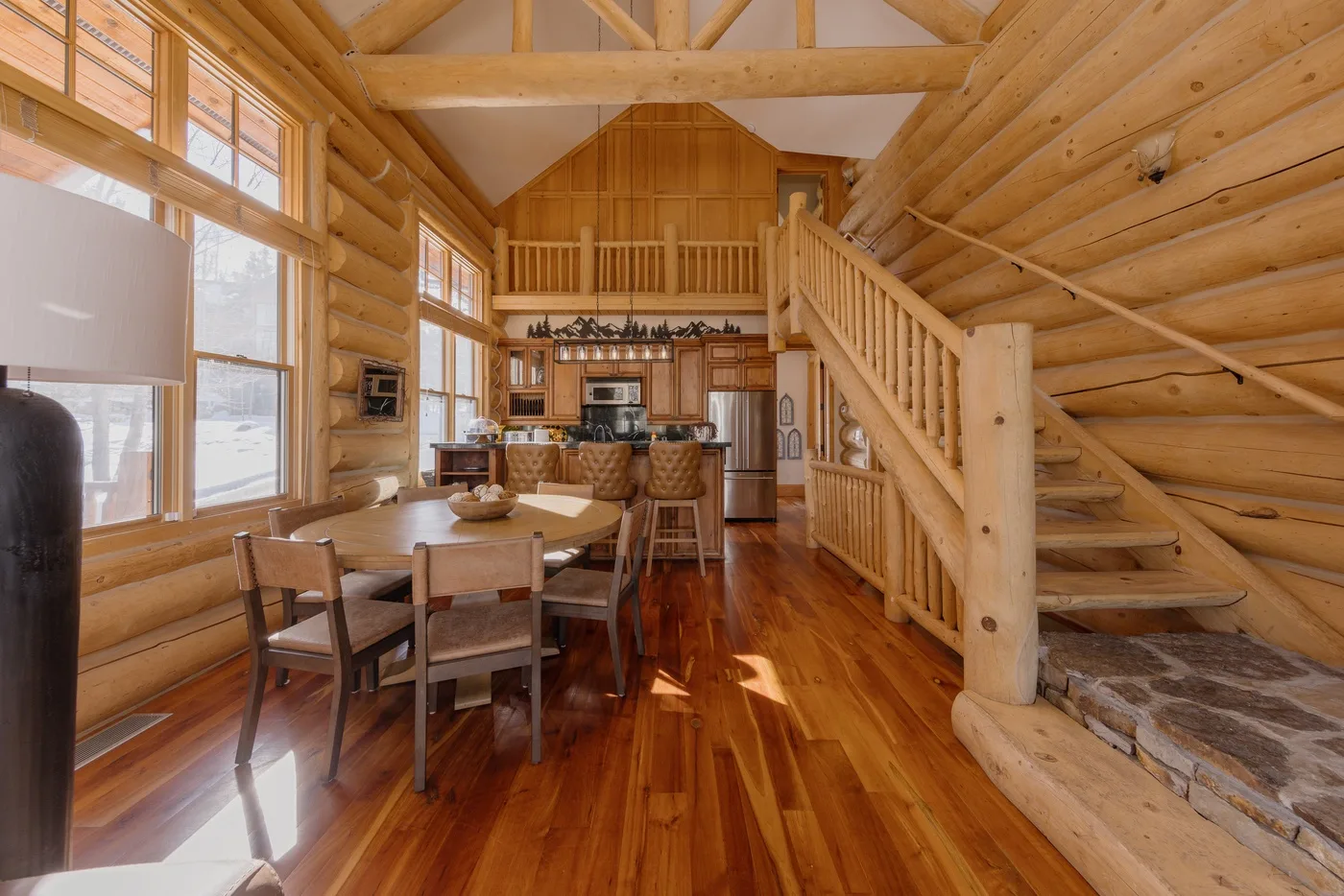 Una sala y comedor revestidos de madera, con cocina y escalera.