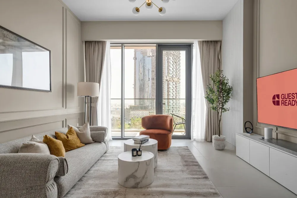 A bright living room with seating, a coffee table, and large windows.