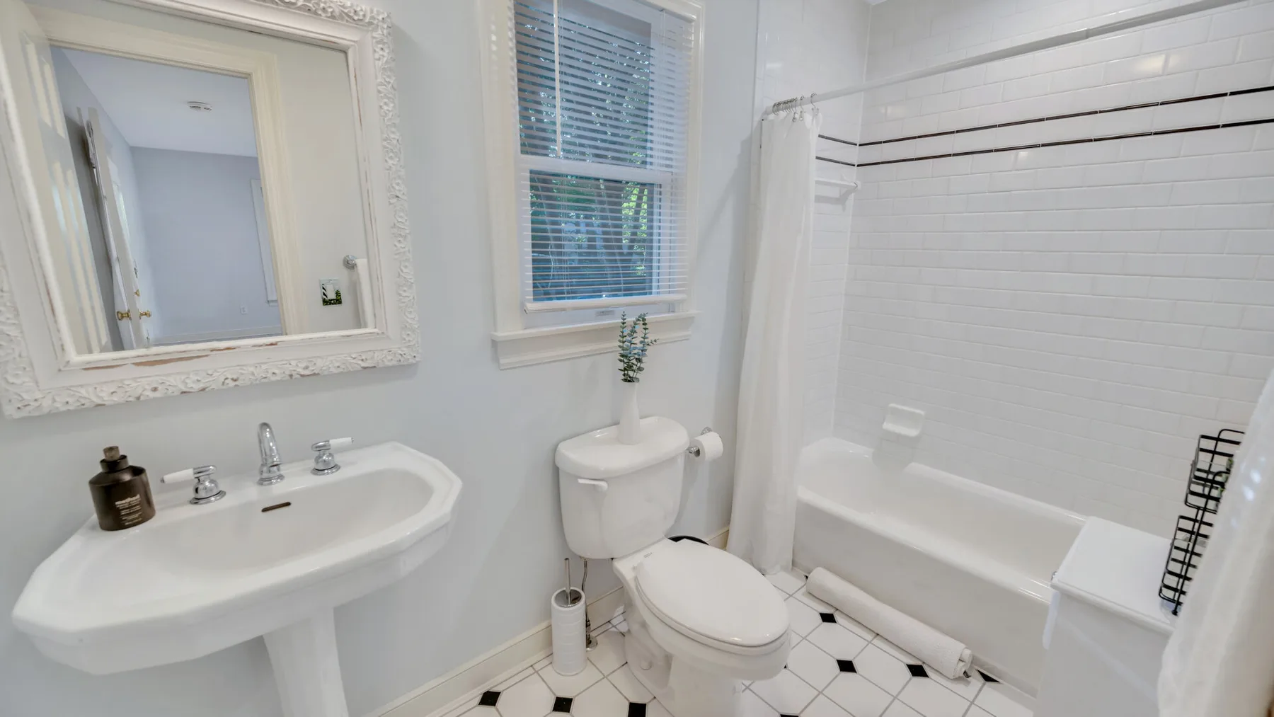 A bright bathroom with a sink, toilet, and bathtub.