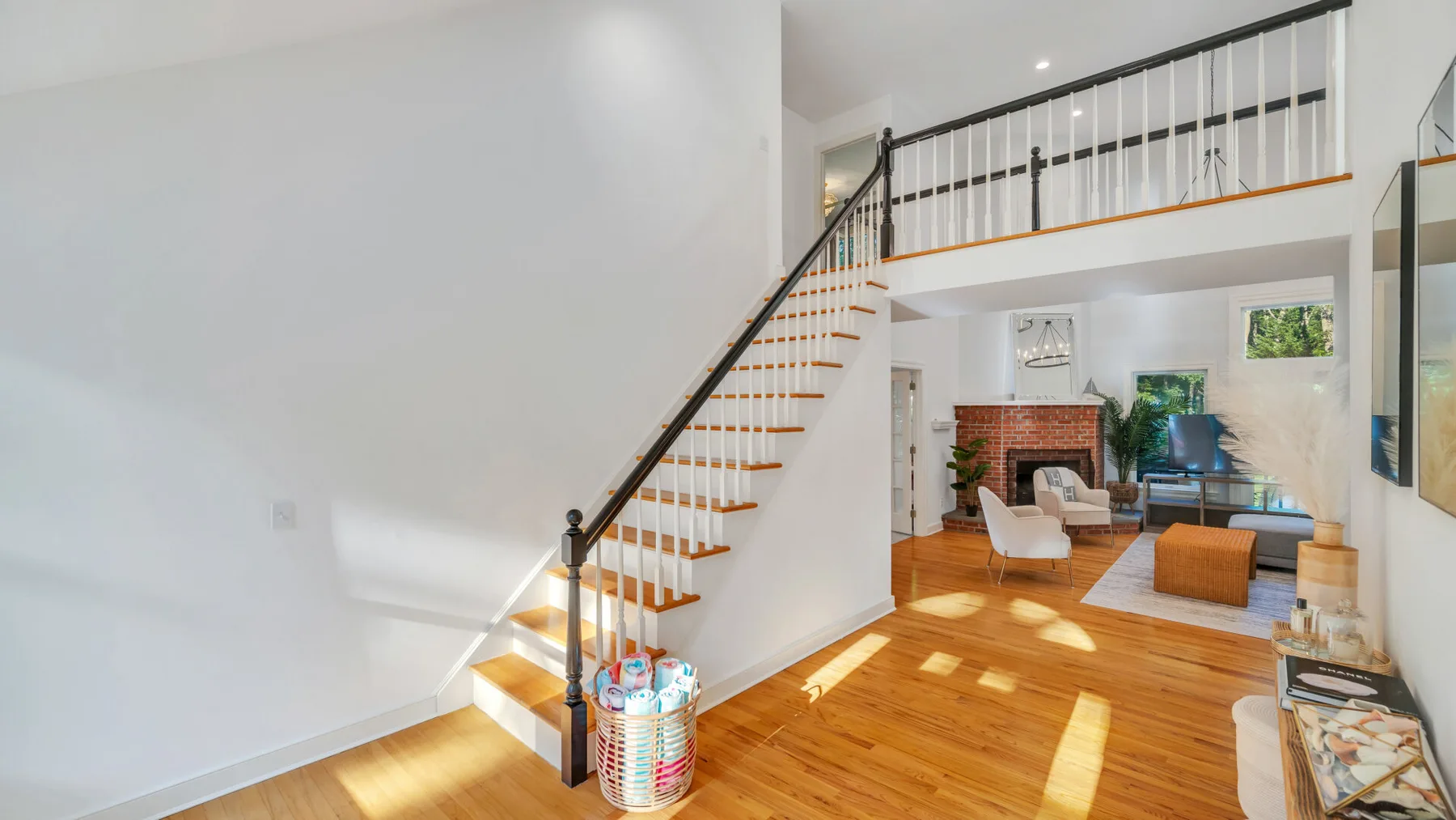 A bright living room with a staircase leading to an upper-level landing.