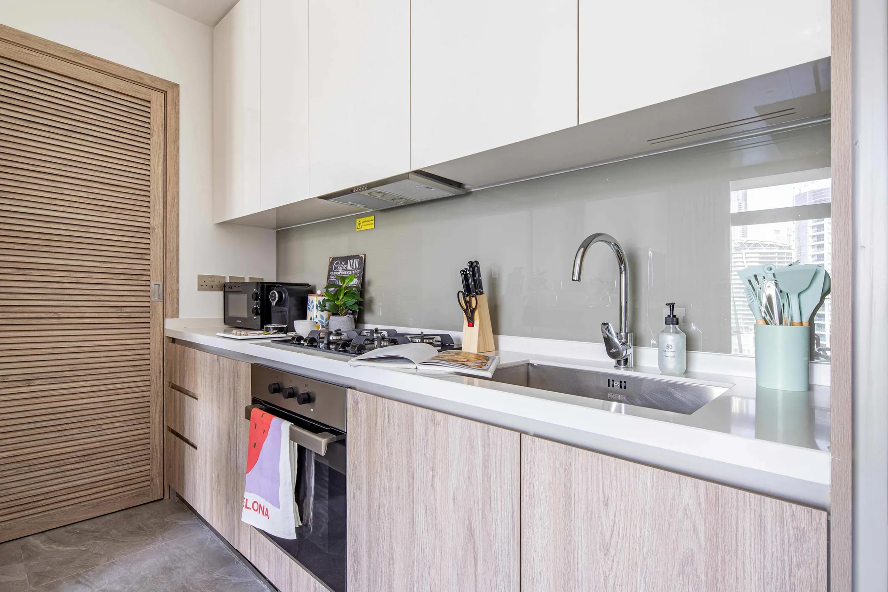 A modern kitchen with a countertop, sink, and cooking area.