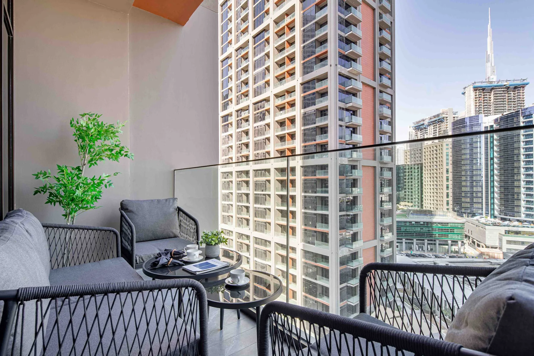 A balcony seating area overlooks several high-rise buildings.