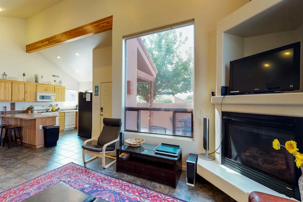 Una luminosa sala de estar abierta con cocina, ventana amplia y chimenea.