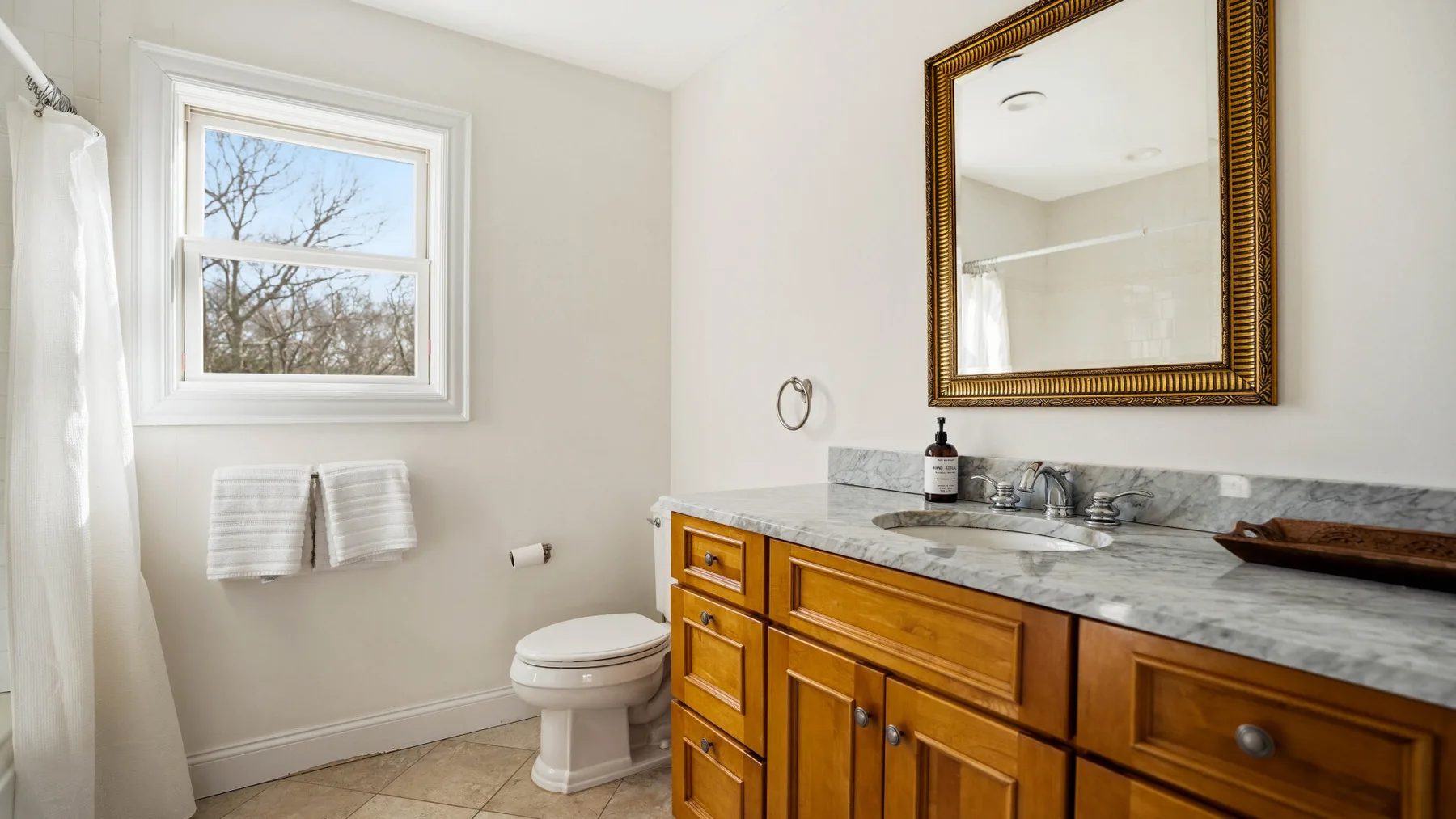 Un baño con lavabo, espejo, inodoro y cortina de ducha.