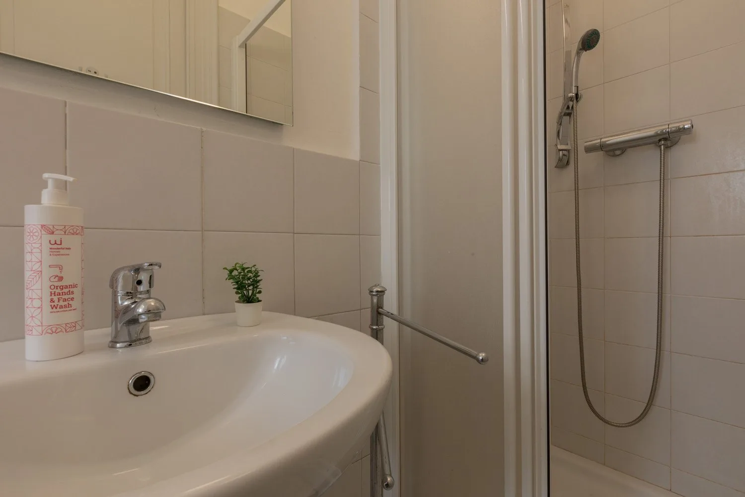 Un baño con lavabo, espejo y ducha.