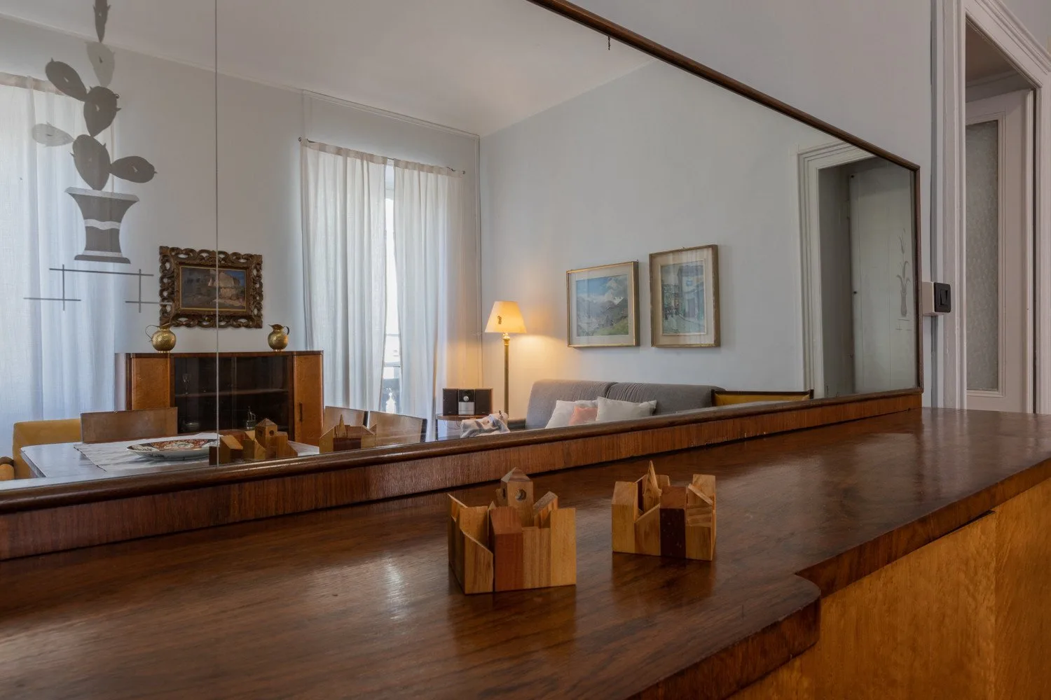 Una sala de estar con un mostrador de madera en primer plano y cuadros en la pared.