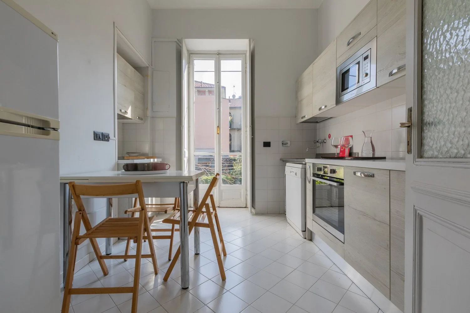 Una cocina luminosa con una mesa de comedor y electrodomésticos.