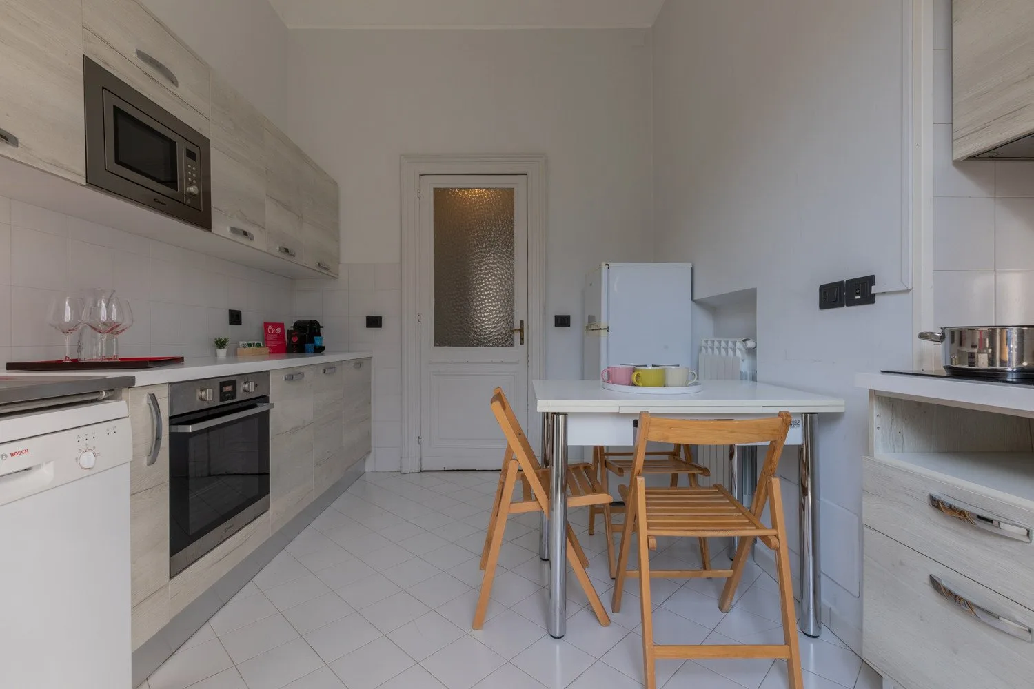 Una cocina luminosa con una mesa de comedor y sillas de madera.