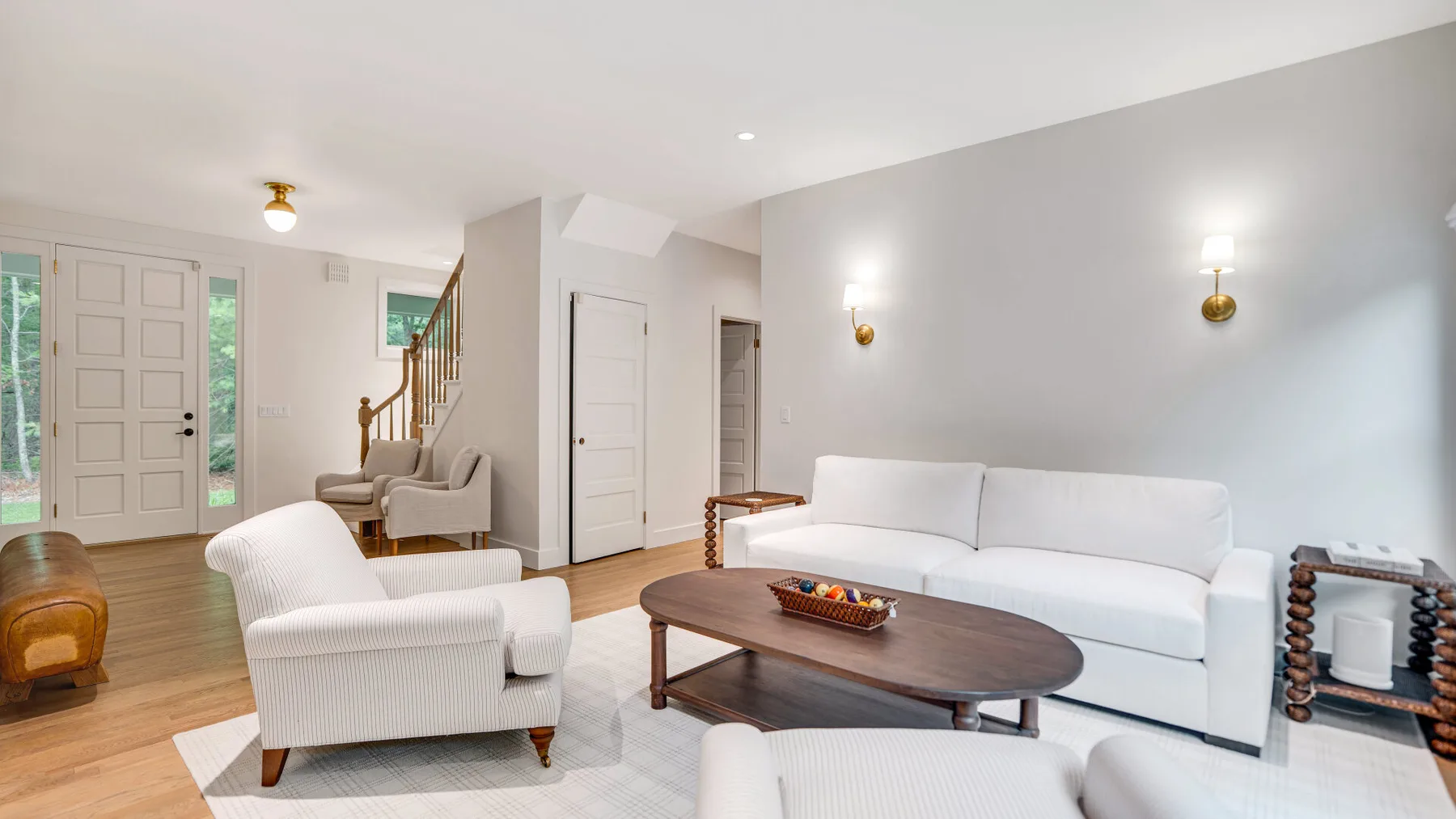 Una sala luminosa con asientos blancos y una mesa de centro de madera.