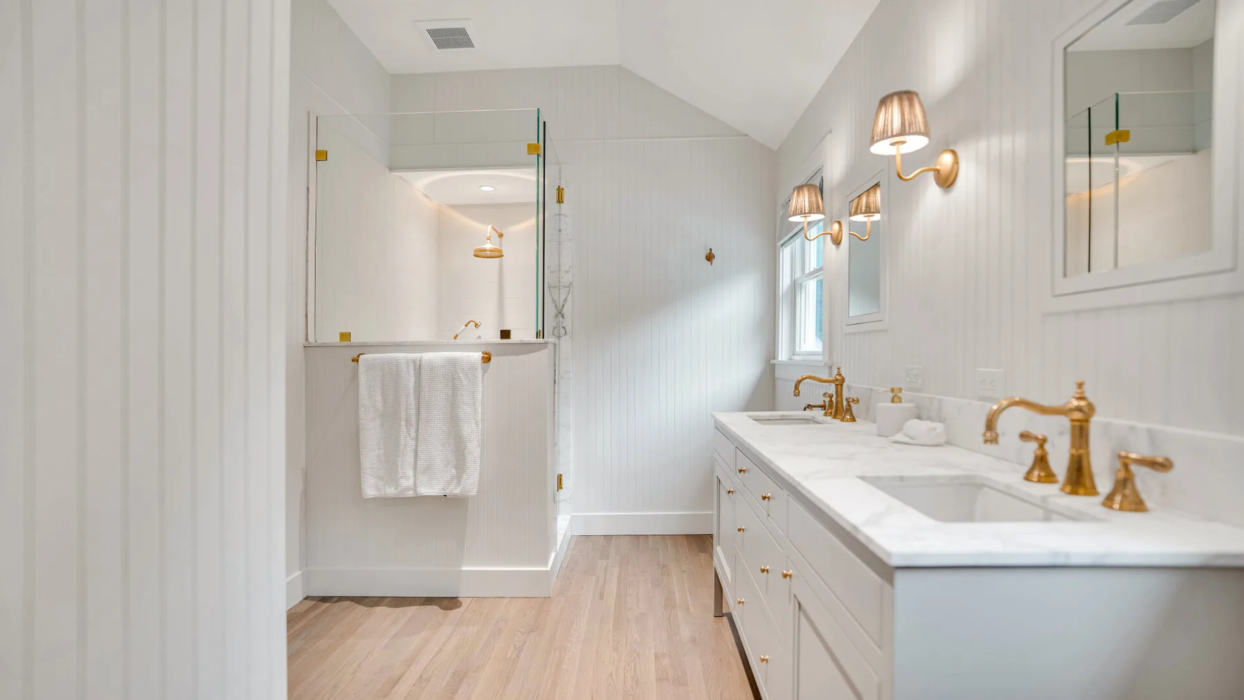 Un baño luminoso con un tocador largo y una bañera.