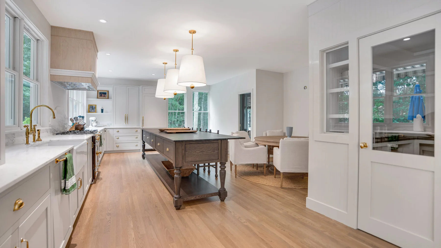 Una cocina y comedor luminosos con una isla central y una mesa.