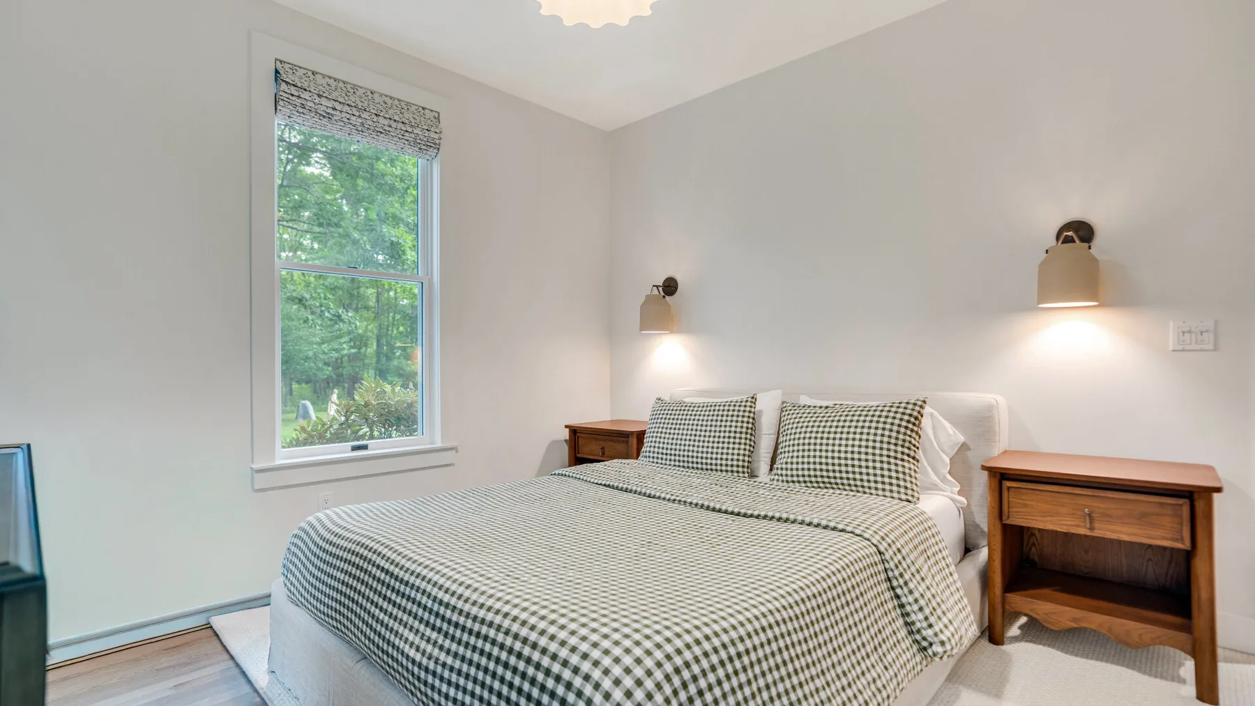 Un dormitorio con una cama cubierta con una colcha de cuadros verdes y blancos.