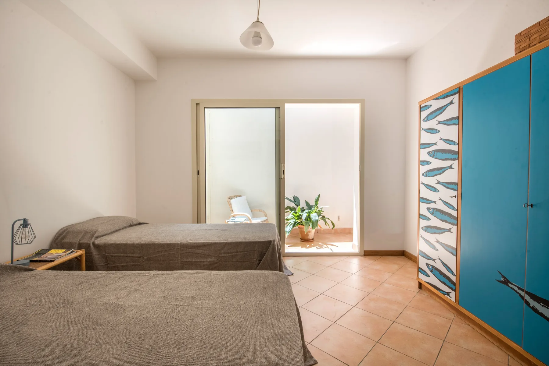 A bedroom with two beds and a blue wardrobe.