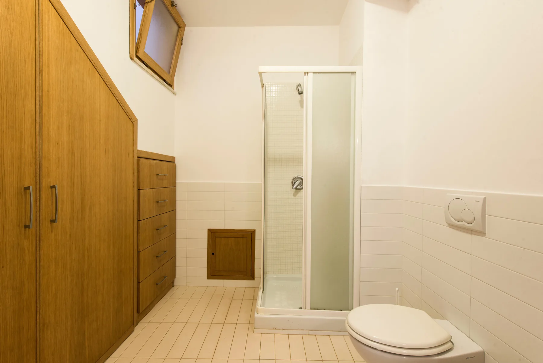 A tiled bathroom with a shower and toilet.