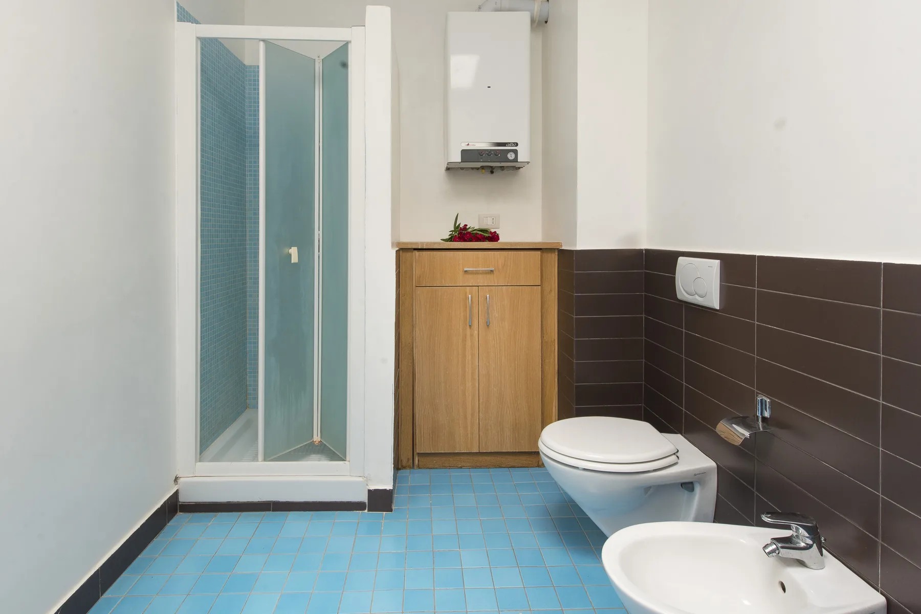 A bathroom with a shower, toilet, and sink.