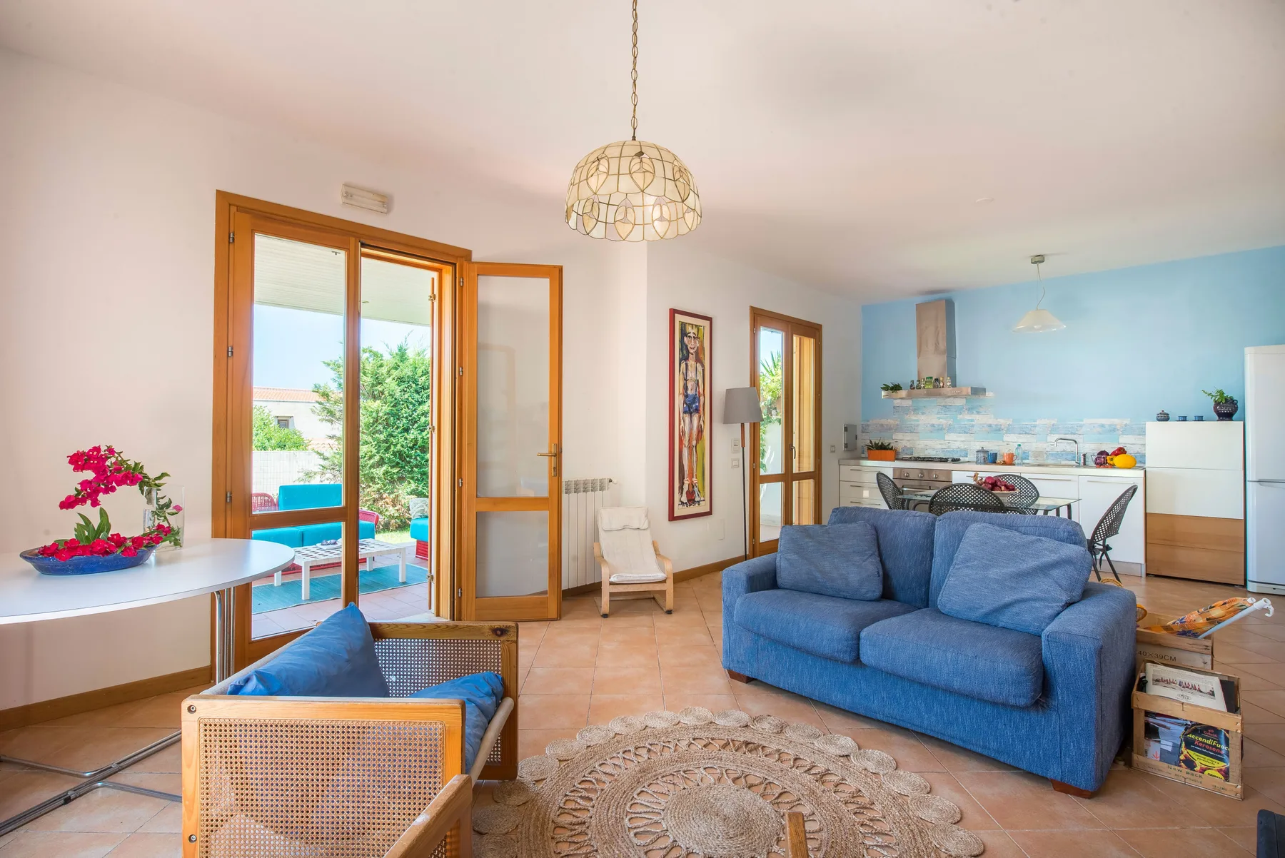 A living room with blue seating and an open view into the kitchen.