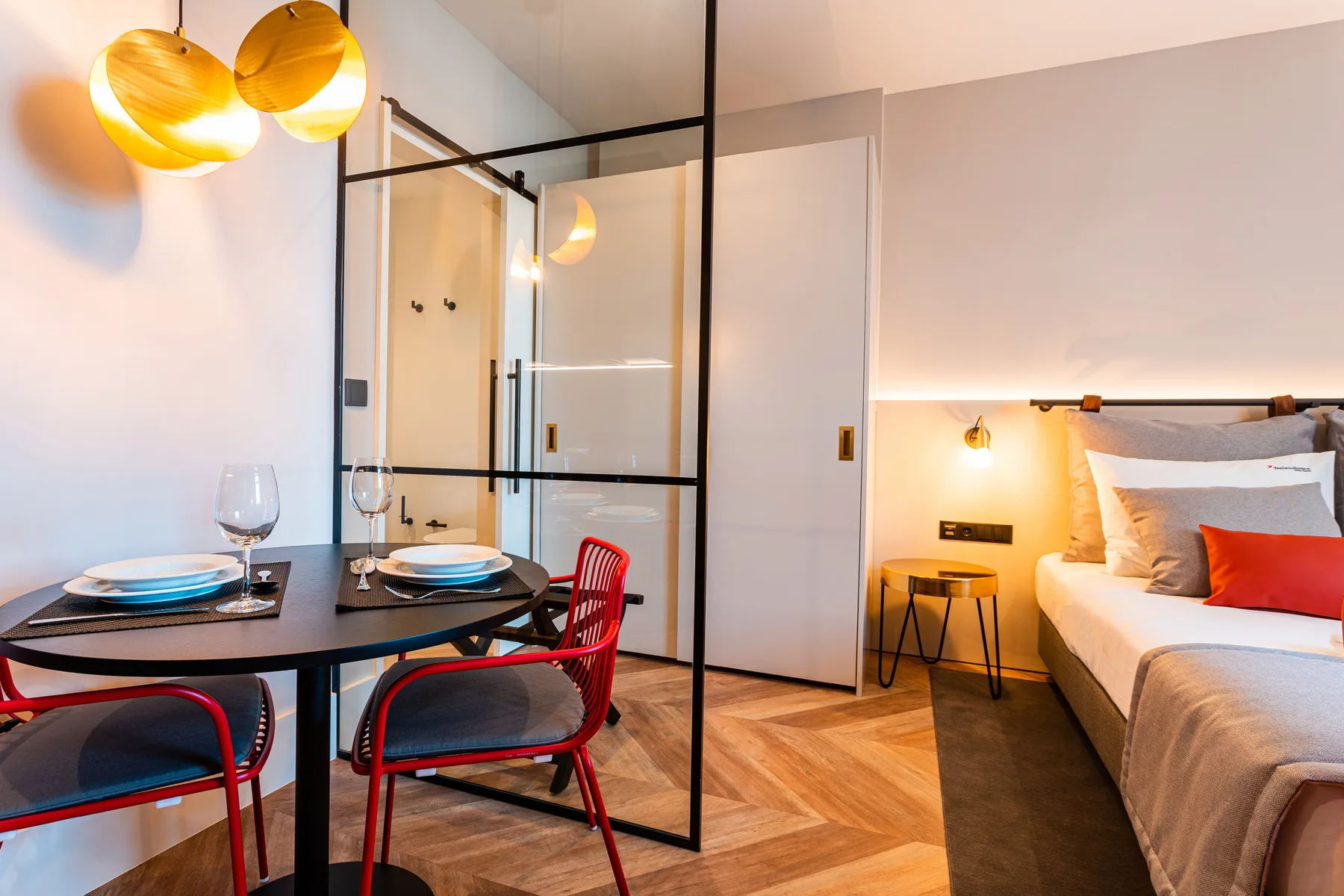 A studio room with a dining table beside the bed.