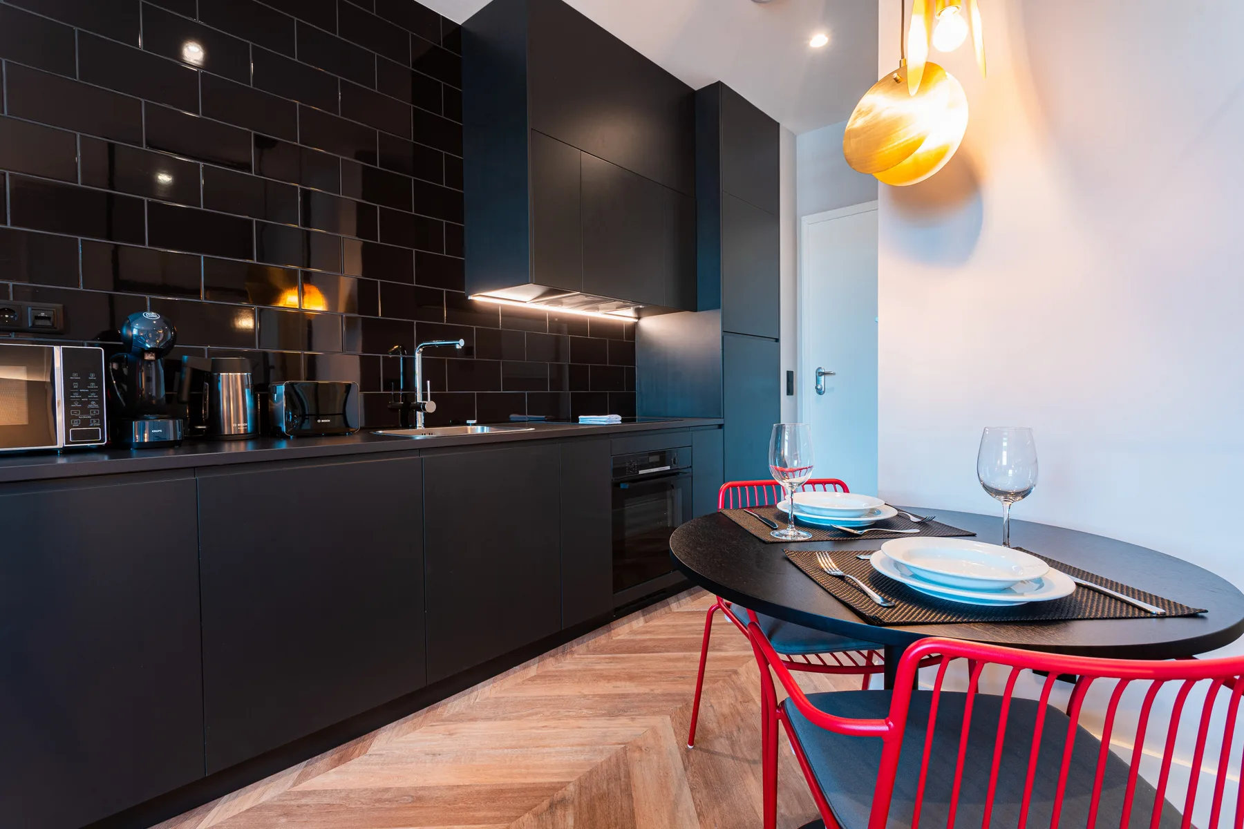 A modern kitchen and dining area with dark cabinets and a set table.