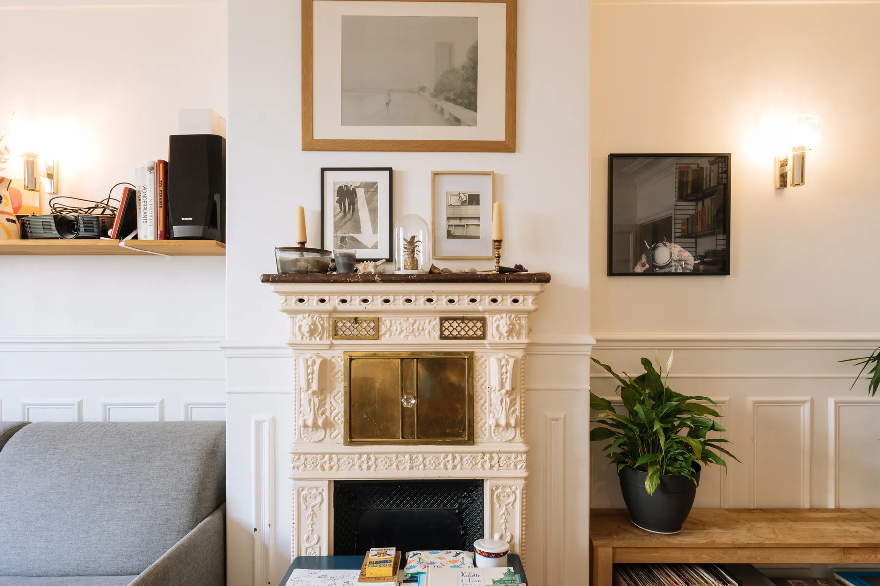 Una sala de estar luminosa con una chimenea decorativa, cuadros y asientos.