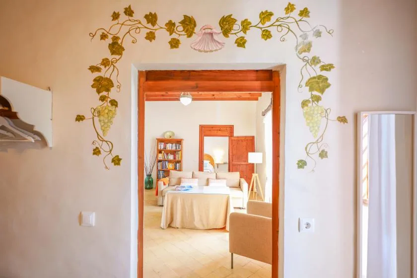 Se ve un dormitorio a través de una puerta, con una cama y una estantería.
