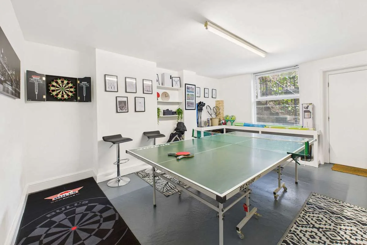 Una sala de recreación con una mesa de ping-pong y una diana.