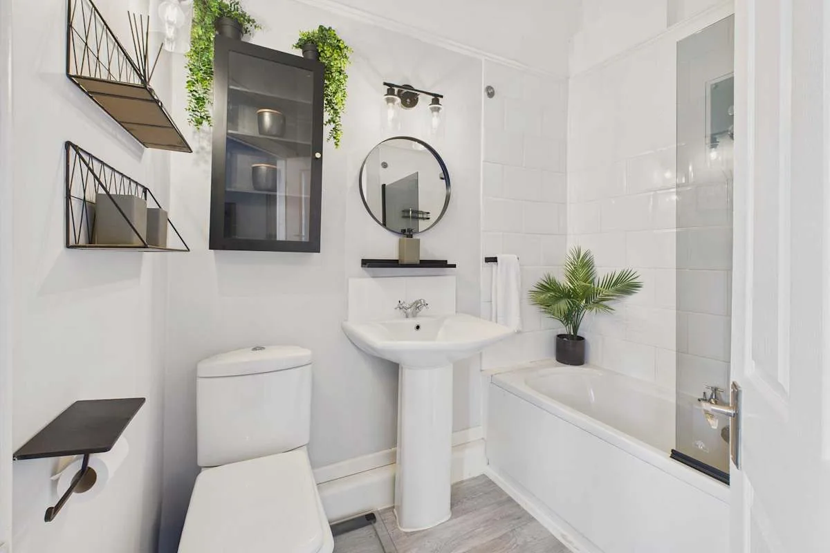 Un baño luminoso con lavabo de pedestal y bañera.