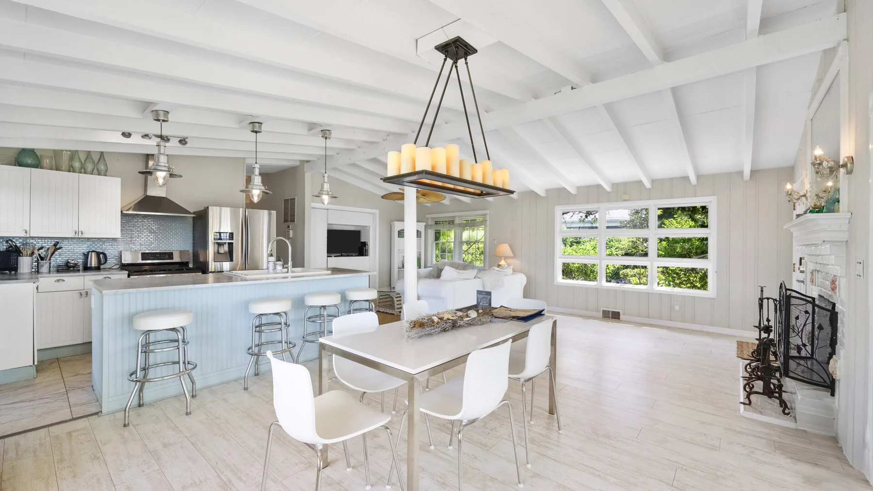 Una luminosa cocina y comedor de concepto abierto, con grandes ventanas y una mesa de comedor.
