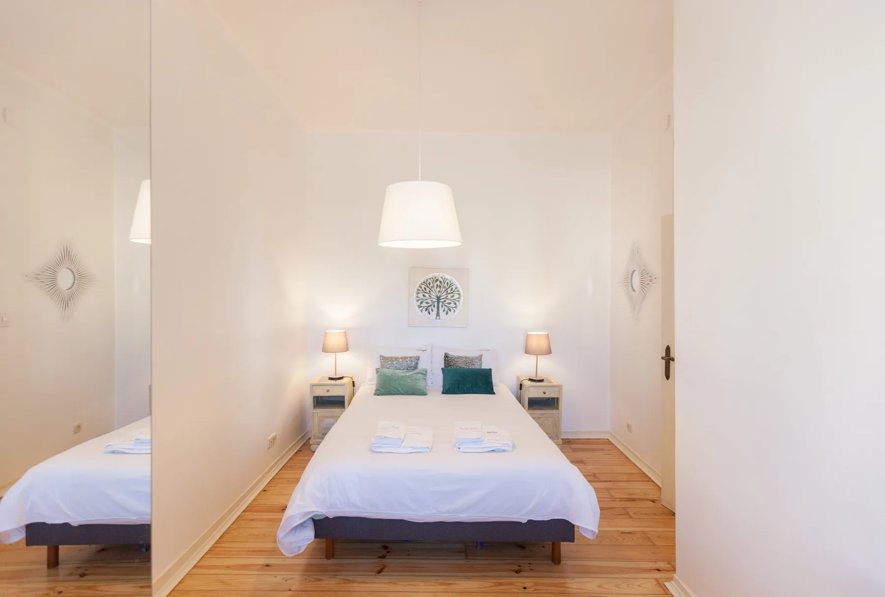 A bedroom with a neatly made bed and matching bedside tables.