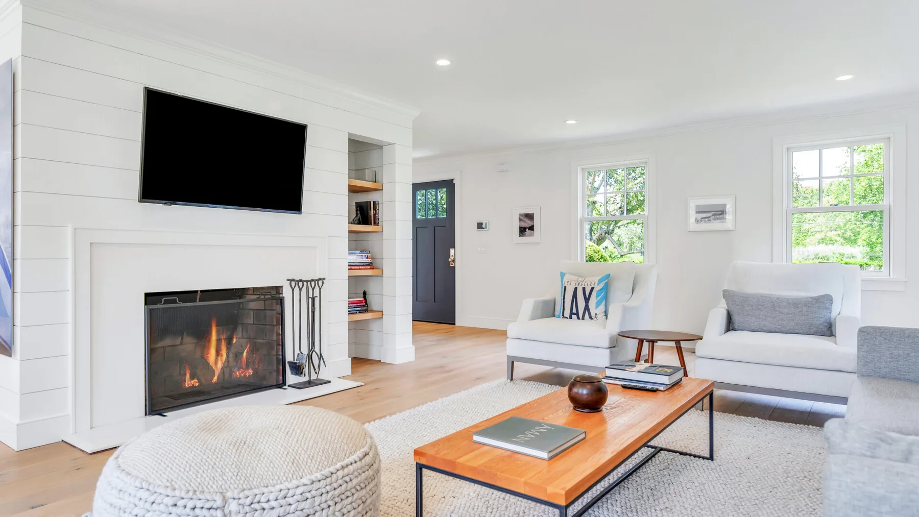 Una sala de estar luminosa con chimenea, televisor y asientos.