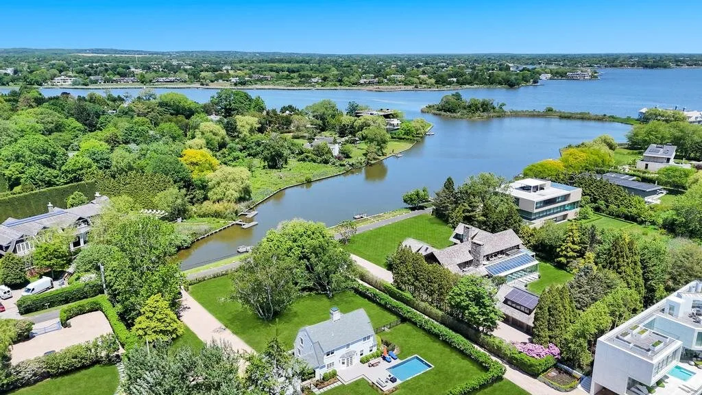 Aerial view of homes and greenery around a winding waterway.