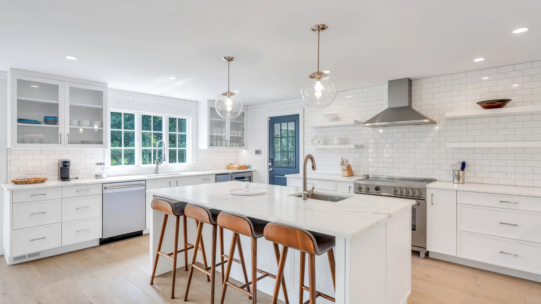 A bright kitchen with a central island and pendant lights.