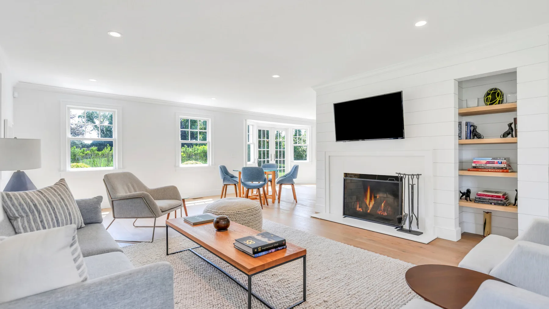 A bright living room with seating, a coffee table, and a fireplace.